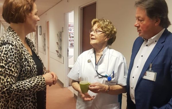 Judith Tielen en bestuurder John Taks in gesprek met zuster Ali, een 90-jarige diacones die al 72 jaar in het Utrechtse stadsziekenhuis werkt.