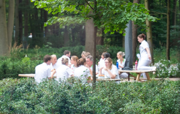 Zorgpersoneel in ziekenhuistuin met veel groen