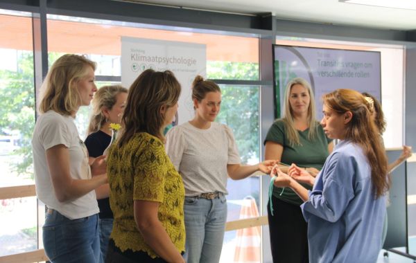 Groepje mensen in gesprek tijdens trainingssessie Stichting Klimaatpsychologie