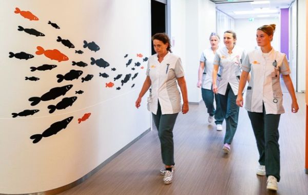 Verpleegkundigen lopend door gang