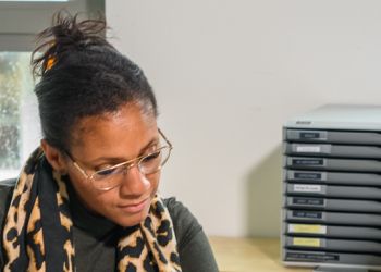 Zorgmedewerker geeft uitleg aan patiënt. Patiënt laat iets zien op telefoon.