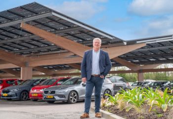 Arno Vredevoort bij de met zonnepanelen overdekte parkeerplaats