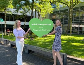 twee leden van de bestuurlijke inspiratie commissie duurzaamheid houden groen hart vast met de tekst het groene besprek bij het spaarne gasthuis