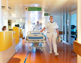 2 verpleegkundigen lopen in ziekenhuisgang