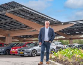 Arno Vredevoort bij de met zonnepanelen overdekte parkeerplaats